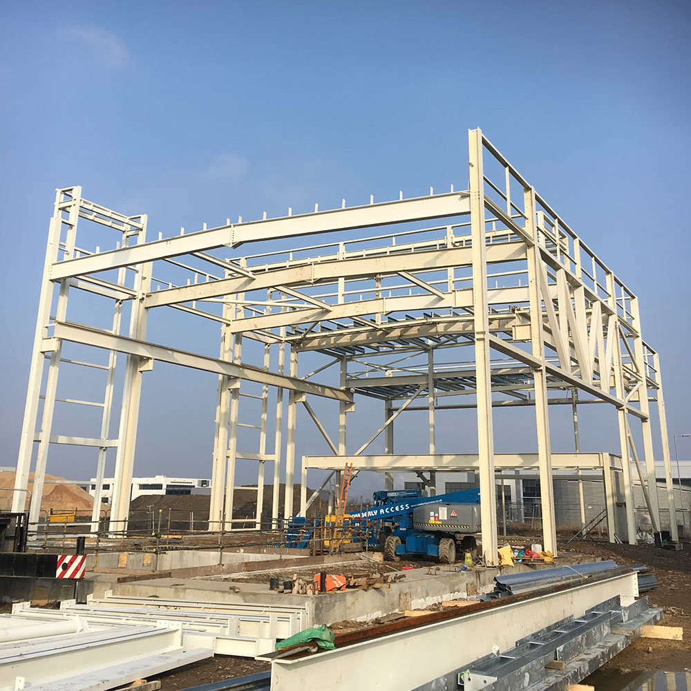 White steel frame in the process of being built in front of a blue sky background, photo taken from the front