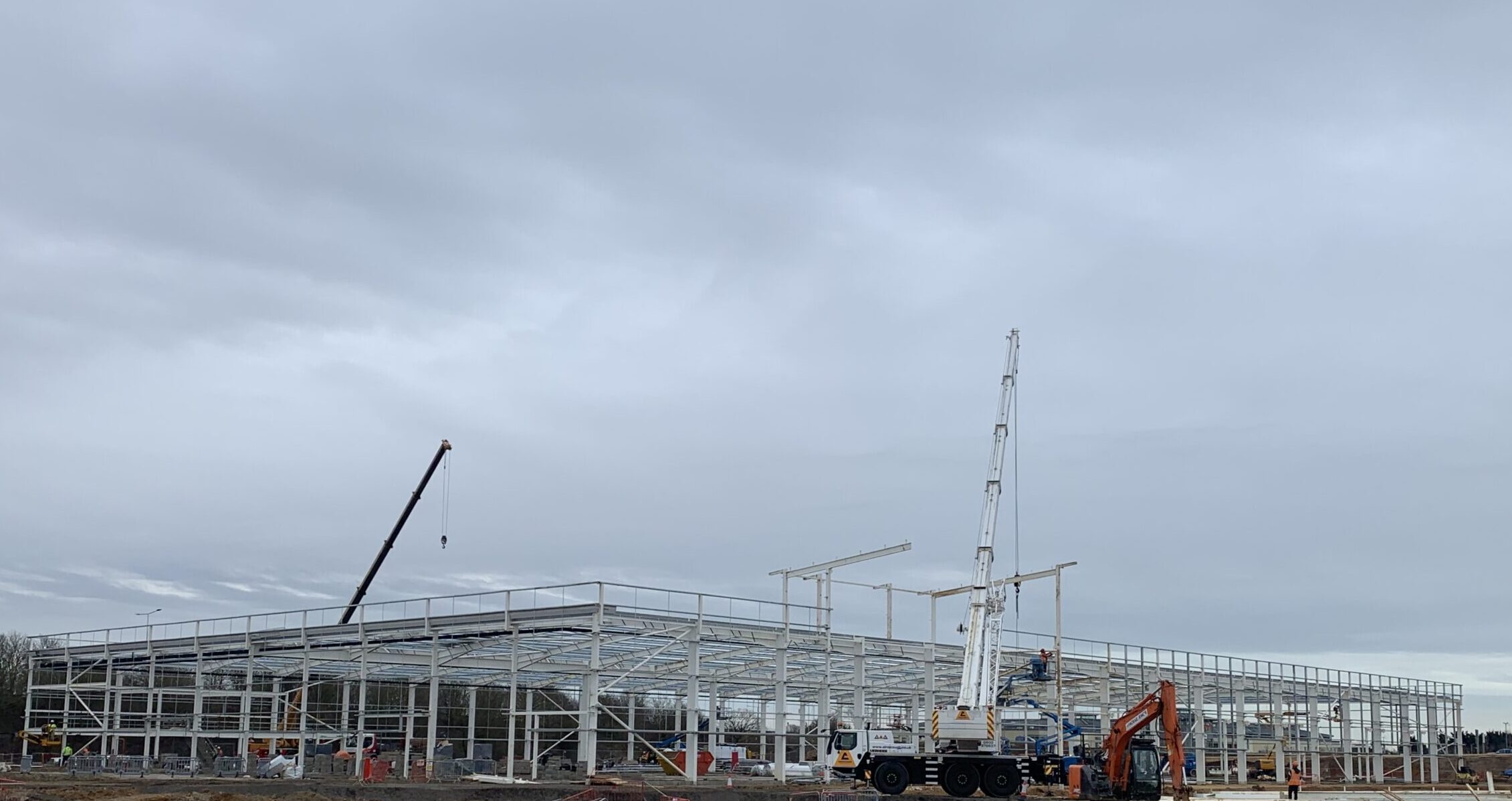 An image of Stane Retail Park's structural frame in construction showing the steel painted white
